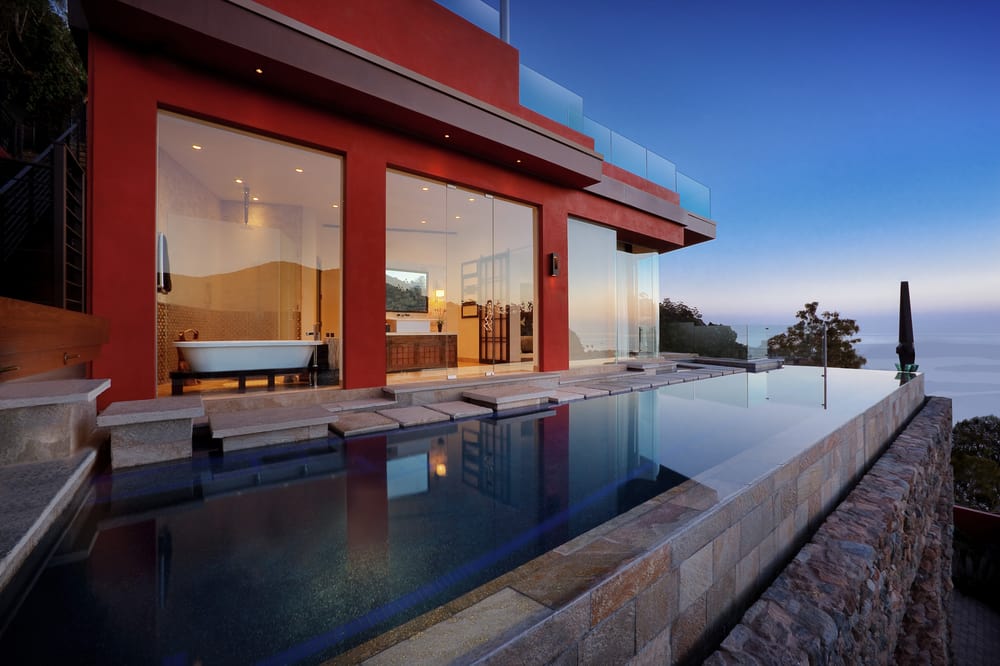 Avanti's infinity pool beside contemporary architecture overlooking the ocean